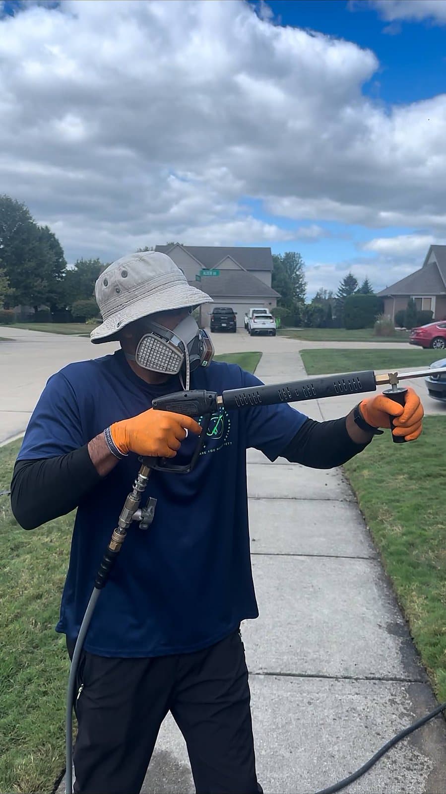 Juan, owner of Are You Washed, pressure washing a driveway in Macomb, MI