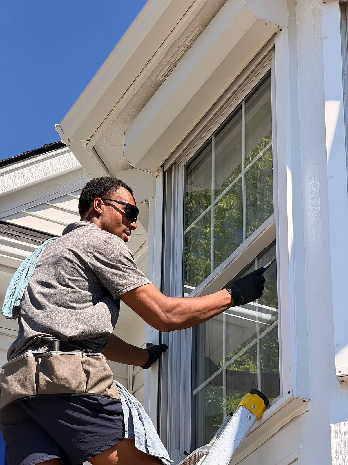 Juan's son cleaning a second-story window on a home in Metro Detroit