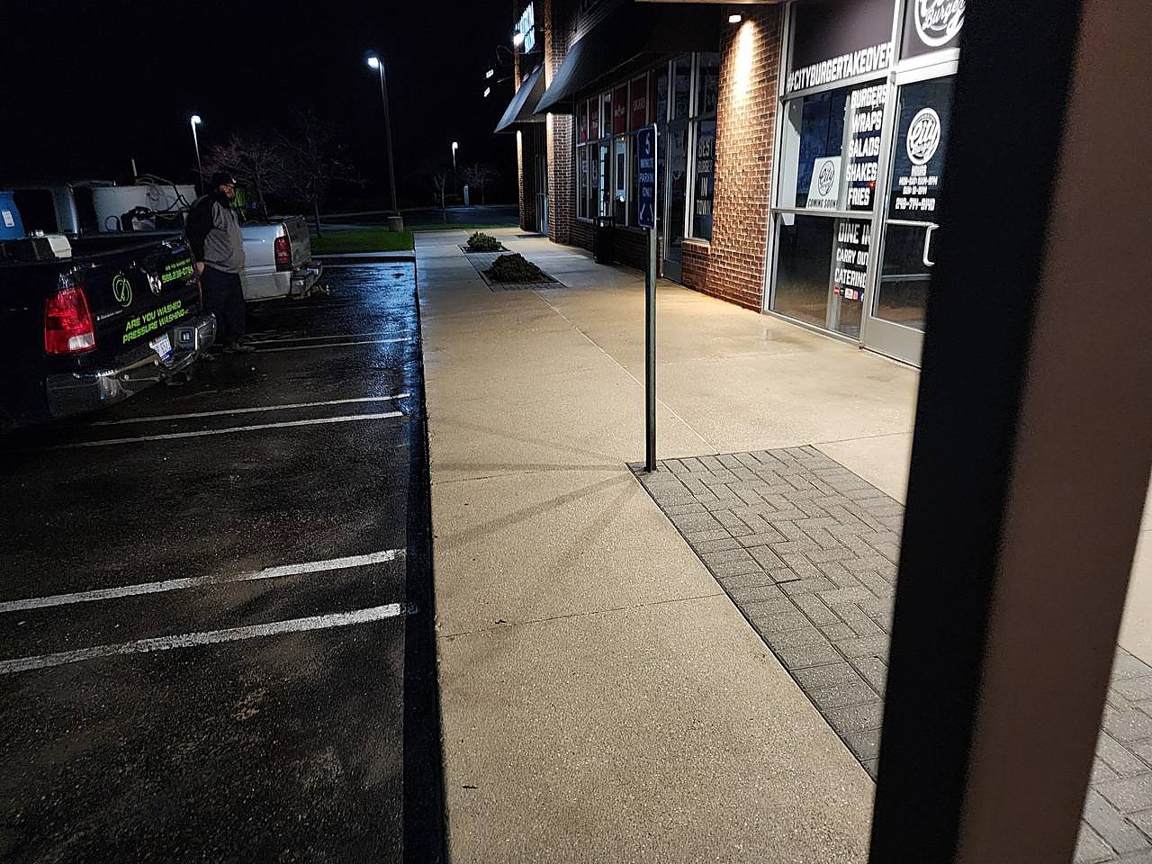 Restaurant sidewalk pressure washed during night service
