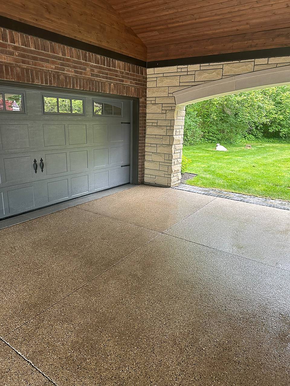 Aggregate concrete by the garage doors pressure washed in Metro Detroit