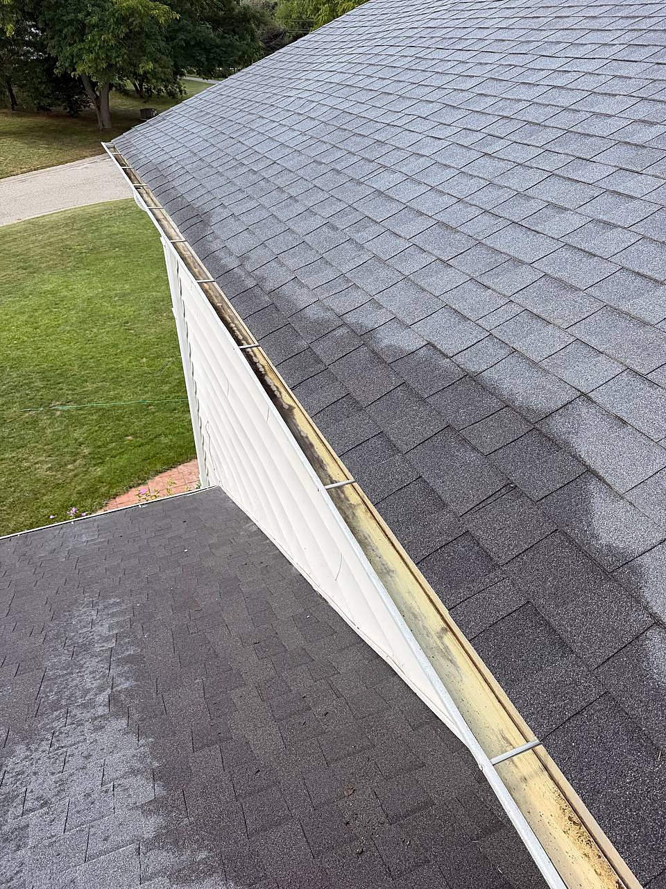Long gutter run cleared along the roofline and siding in Sterling Heights