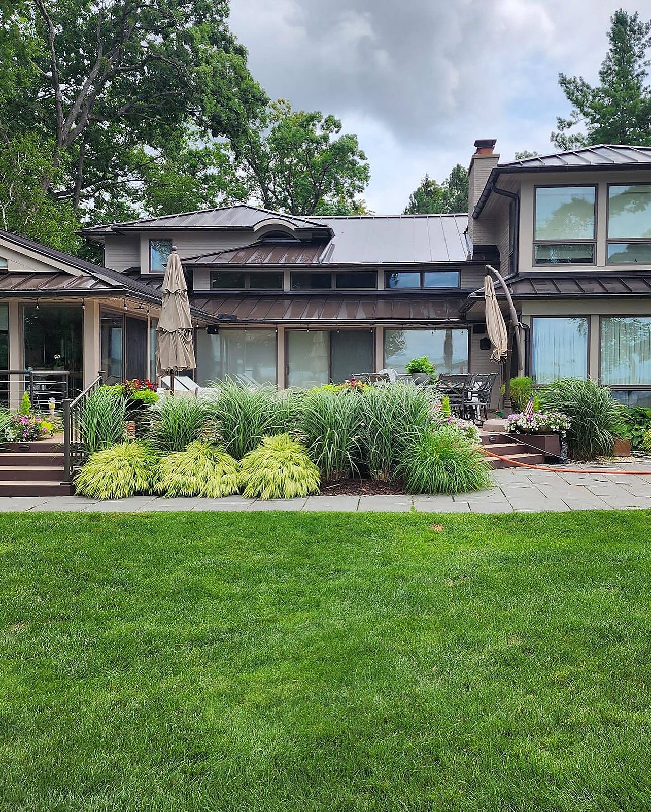 Modern lakeside home with washed siding and metal roof in Metro Detroit