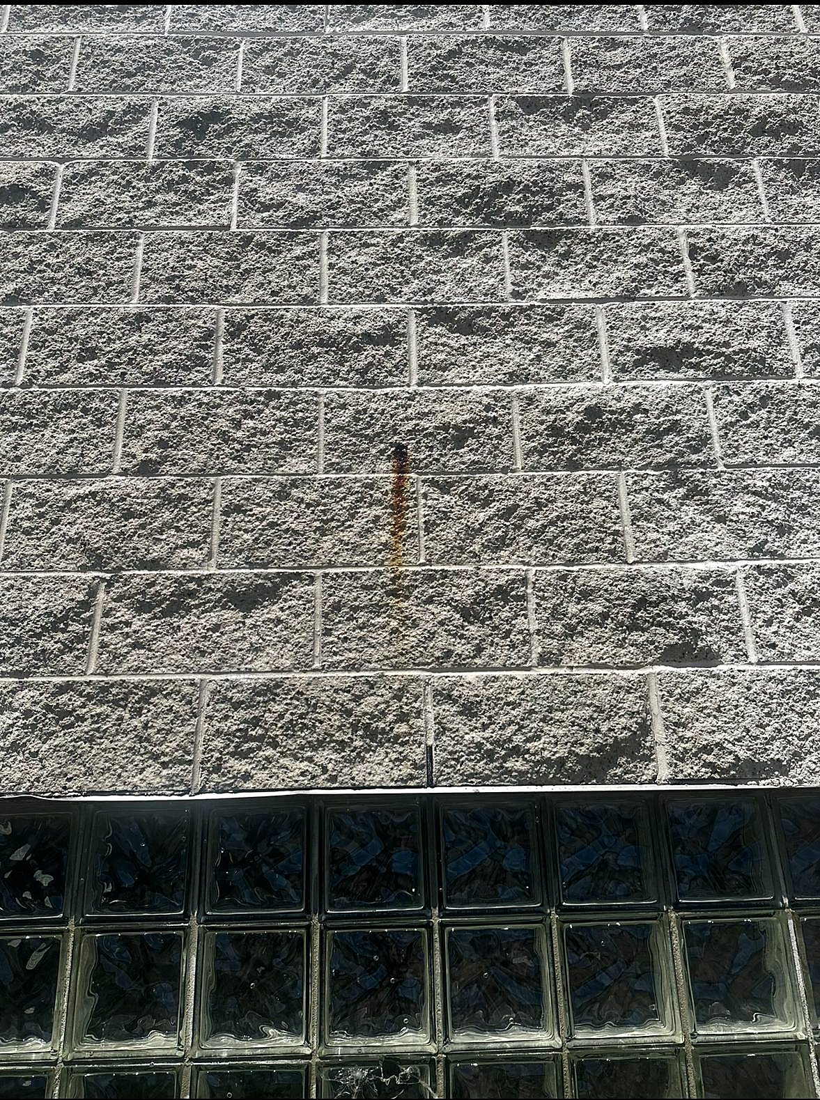 Rust stain on block wall before removal in Metro Detroit