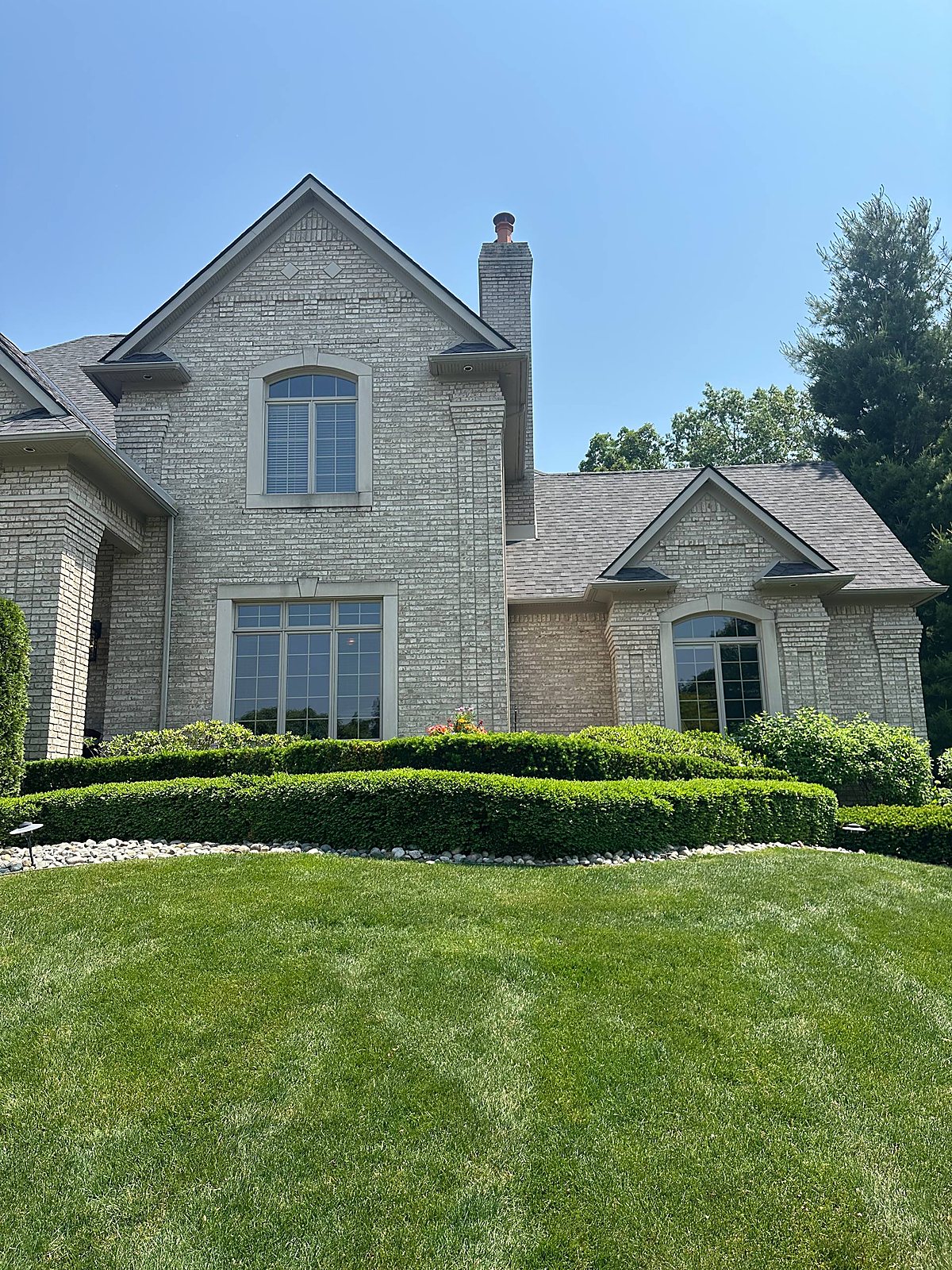 Gray brick facade with arched window cleaned in Macomb County
