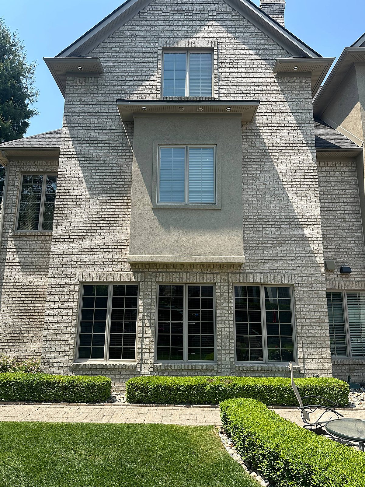 Gable windows cleaned streak-free beside herringbone brick in Macomb, MI