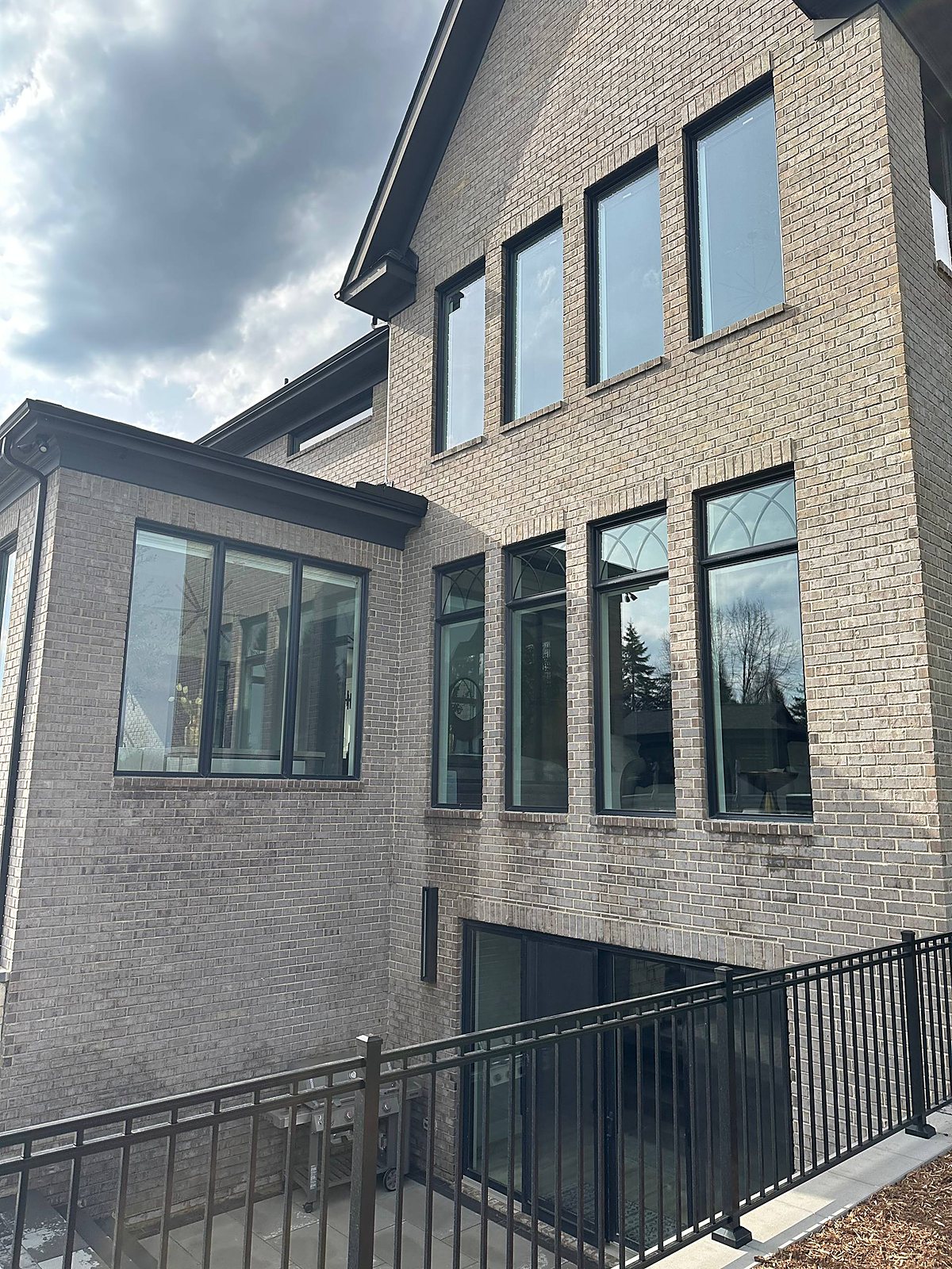 Gray brick home, second story windows cleaned in Metro Detroit