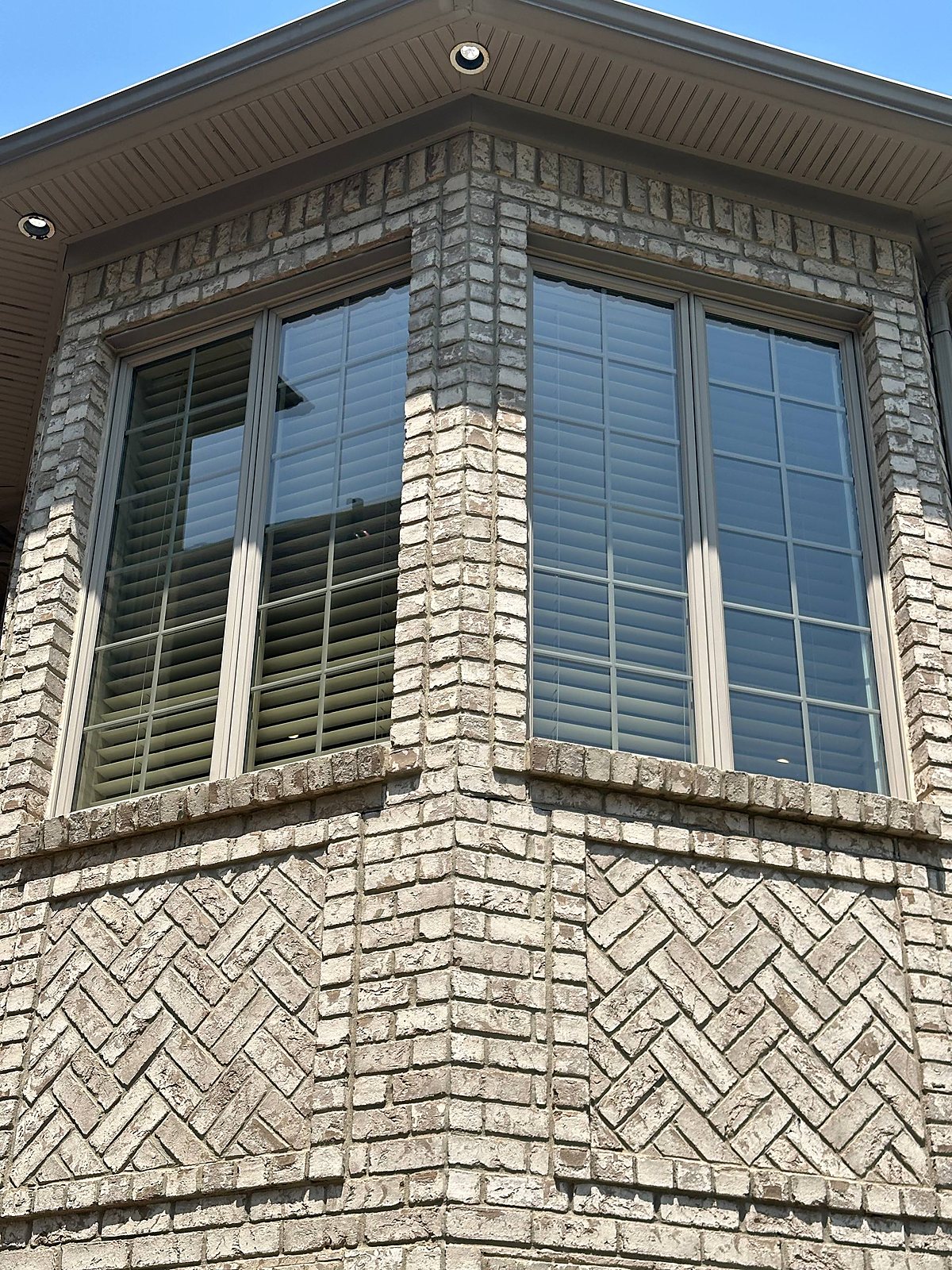 Divided light windows cleaned on a gray brick and stucco home in Macomb County