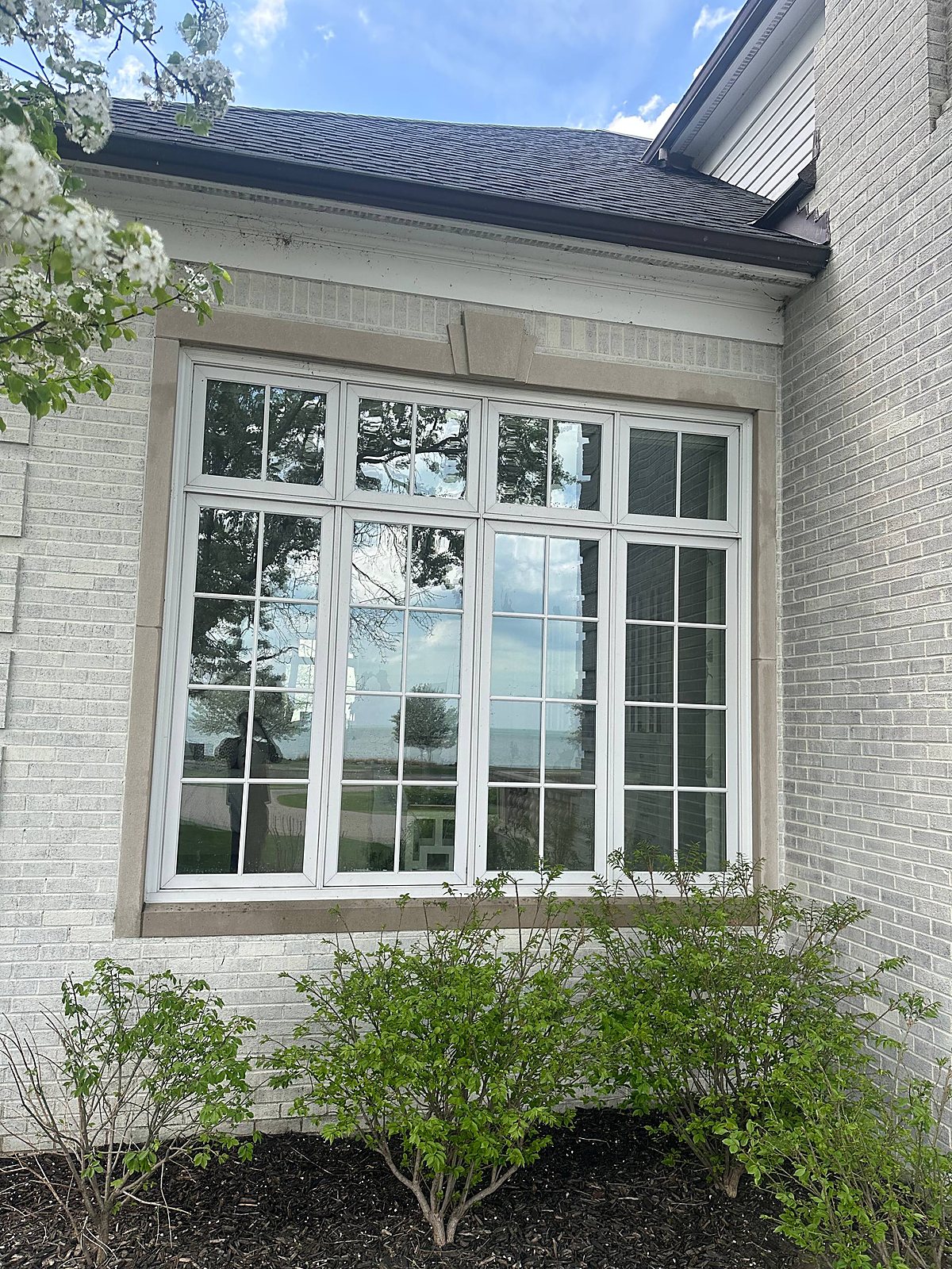 Tall grid window cleaned clear on a painted brick home in Metro Detroit